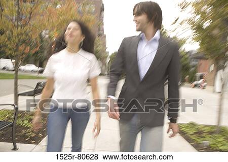 Stock Photo - Young couple walking together in a park. Fotosearch