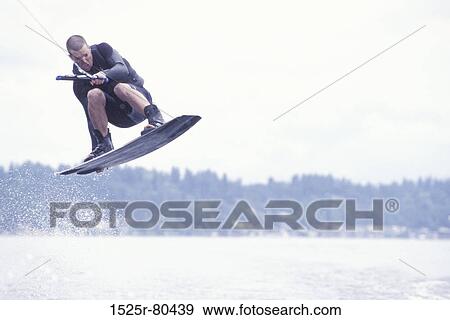 Young man kiteboarding in the sea View Large Photo Image Stock Photo - Young man kiteboarding in the sea. Fotosearch