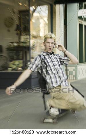 Young man talking on the mobile phone while skateboarding View Large Photo Image Stock Image - Young man talking on the mobile phone while skateboarding. Fotosearch