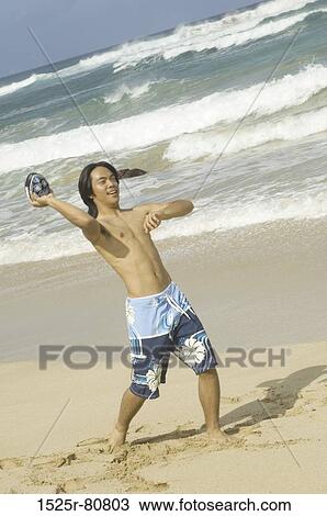 Young man throwing a ball on the beach View Large Photo Image Stock Image - Young man throwing a ball on the beach. Fotosearch