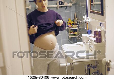 Young pregnant woman standing in the bathroom View Large Photo Image Stock Photograph - Young pregnant woman standing in the bathroom. Fotosearch