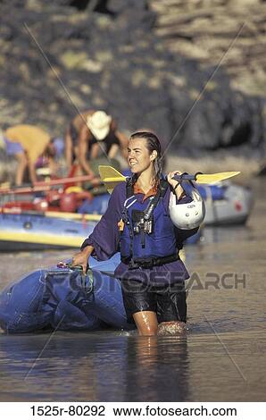 Young woman holding an inflatable raft and an oar View Large Photo Image Stock Image - Young woman holding an inflatable raft and an oar. Fotosearch