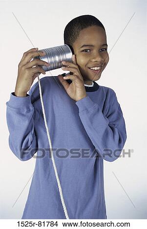 Picture - Boy playing with a tin can phone. Fotosearch
