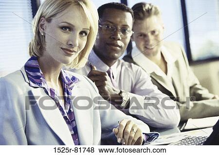 Business executives in an office looking at camera View Large Photo Image Stock Photo - Business executives in an office looking at camera. Fotosearch