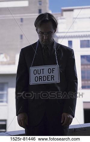 Stock Photograph - Businessman standing with an out of order sign around his neck. Fotosearch