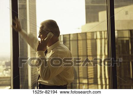 Businessman talking on a landline telephone View Large Photo Image Picture - Businessman talking on a landline telephone. Fotosearch