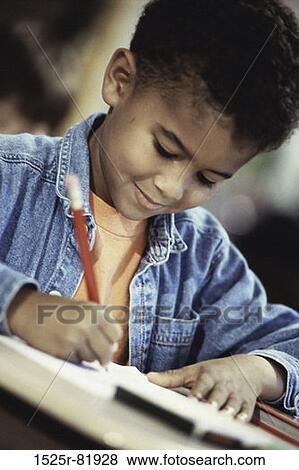 Close-up of a boy writing in a book with a pencil View Large Photo Image Stock Photo - Close-up of a boy writing in a book with a pencil. Fotosearch