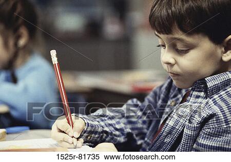 Close-up of a boy writing in a book with a pencil View Large Photo Image Stock Photography - Close-up of a boy writing in a book with a pencil. Fotosearch