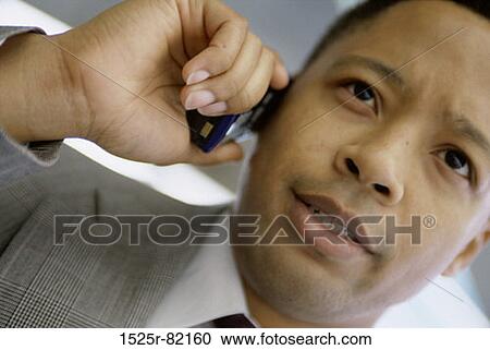 Close-up of a businessman talking on a mobile phone View Large Photo Image Stock Image - Close-up of a businessman talking on a mobile phone. Fotosearch