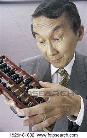Close-up of a businessman using an abacus View Large Photo Image Stock Image - Close-up of a businessman using an abacus. Fotosearch