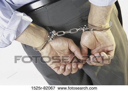 Close-up of a businessman with his hands handcuffed behind his back View Large Photo Image Stock Photo - Close-up of a businessman with his hands handcuffed behind his back. Fotosearch