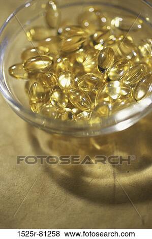 Stock Photo - Close-up of a glass full of vitamin capsules. Fotosearch