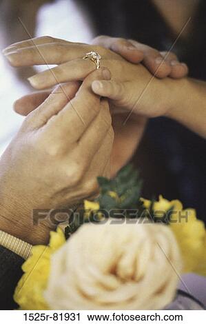 Close-up of a man putting a ring on a young woman's finger View Large Photo Image Stock Image - Close-up of a man putting a ring on a young woman's finger. Fotosearch
