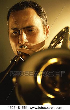 Close-up of a mid adult man playing the trombone View Large Photo Image Stock Image - Close-up of a mid adult man playing the trombone. Fotosearch
