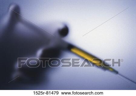 Close-up of a person holding a syringe View Large Photo Image Stock Photo - Close-up of a person holding a syringe. Fotosearch
