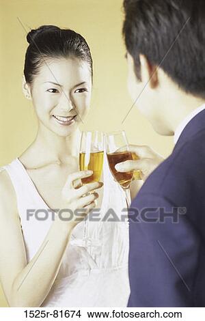 Close-up of a young couple toasting View Large Photo Image Picture - Close-up of a young couple toasting. Fotosearch