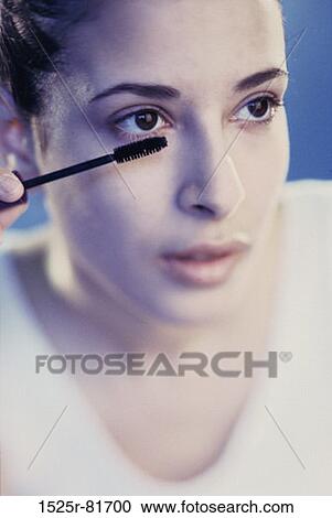 Close-up of a young woman applying mascara View Large Photo Image Stock Image - Close-up of a young woman applying mascara. Fotosearch