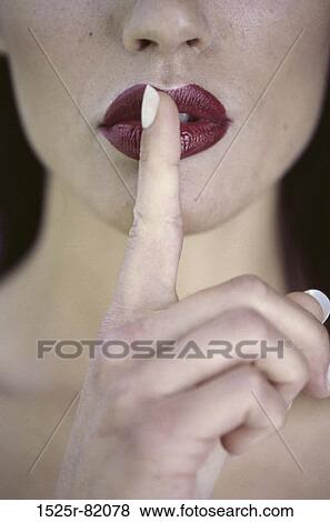 Close-up of a young woman with her finger on her lip View Large Photo Image Stock Photo - Close-up of a young woman with her finger on her lip. Fotosearch