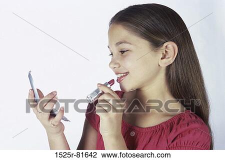 Girl applying lipstick holding a mirror View Large Photo Image Stock Image - Girl applying lipstick holding a mirror. Fotosearch