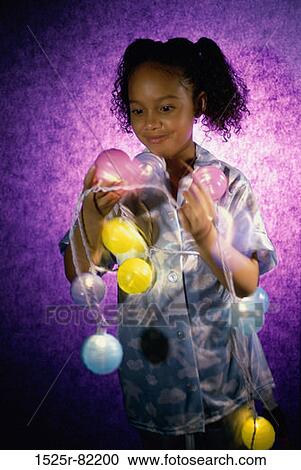 Girl holding a string of colored lights View Large Photo Image Stock Image - Girl holding a string of colored lights. Fotosearch