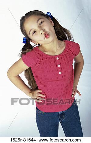 Picture - Girl puckering her lips standing arms akimbo. Fotosearch