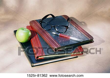 Granny Smith apple with a pen and eyeglasses on books View Large Photo Image Stock Image - Granny Smith apple with a pen and eyeglasses on books. Fotosearch