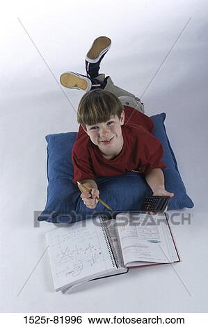 High angle view of a boy lying on the floor doing homework View Large Photo Image Stock Photograph - High angle view of a boy lying on the floor doing homework. Fotosearch