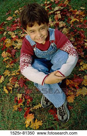 High angle view of a boy sitting on a lawn looking up View Large Photo Image Stock Image - High angle view of a boy sitting on a lawn looking up. Fotosearch