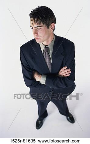 Stock Photography - High angle view of a businessman standing with arms folded. Fotosearch