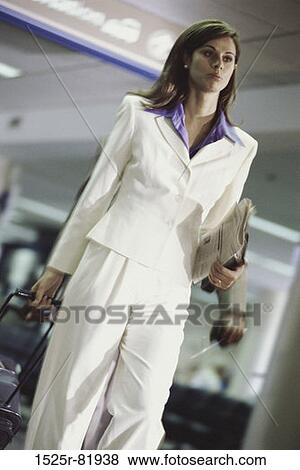 Low angle view of a businesswoman pulling a suitcase View Large Photo Image Stock Photo - Low angle view of a businesswoman pulling a suitcase. Fotosearch