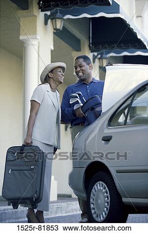 Low angle view of a young couple packing luggage into a car View Large Photo Image Stock Image - Low angle view of a young couple packing luggage into a car. Fotosearch