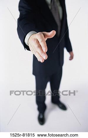 Stock Photography - Low section view of a businessman holding out his hand. Fotosearch
