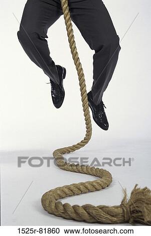 Low section view of a man climbing a rope View Large Photo Image Stock Image - Low section view of a man climbing a rope. Fotosearch