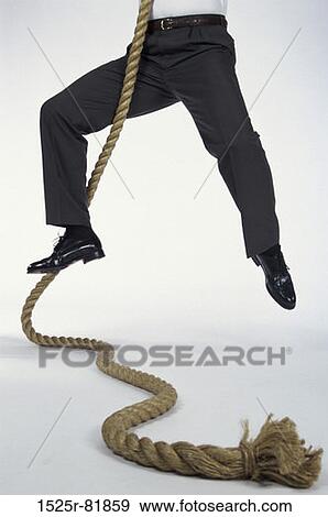 Low section view of a man climbing a rope View Large Photo Image Stock Photo - Low section view of a man climbing a rope. Fotosearch