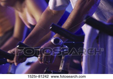 Low section view of people cycling in a gym View Large Photo Image Stock Image - Low section view of people cycling in a gym. Fotosearch