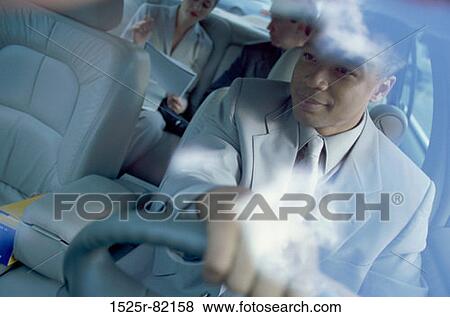 Male chauffeur driving a car with two passengers View Large Photo Image Stock Photo - Male chauffeur driving a car with two passengers. Fotosearch