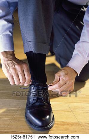 Stock Image - Man tying his shoelace. Fotosearch
