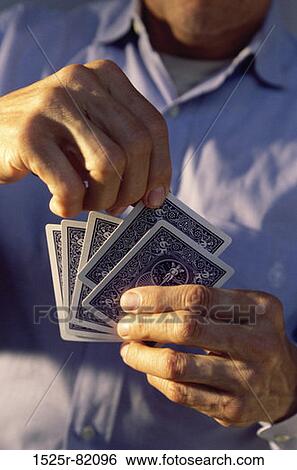 Mid section view of a man holding playing cards View Large Photo Image Stock Photograph - Mid section view of a man holding playing cards. Fotosearch