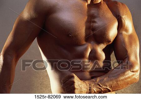Stock Photo - Mid section view of a young man flexing his muscles. Fotosearch