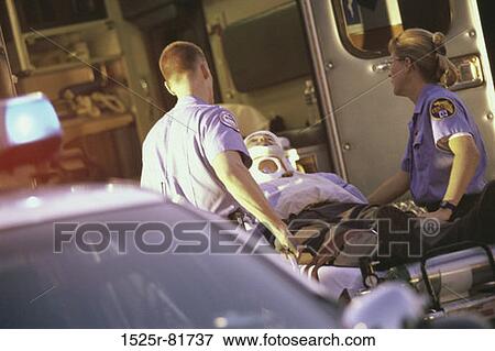 Stock Photo - Paramedics putting a patient into an ambulance. Fotosearch