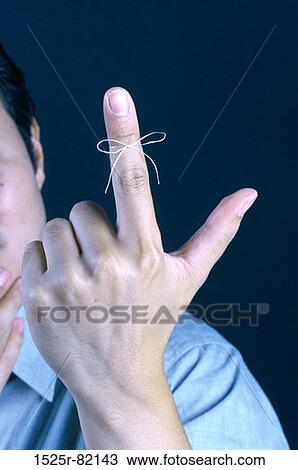 Person holding out his finger with a string tied around it View Large Photo Image Stock Image - Person holding out his finger with a string tied around it. Fotosearch