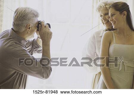 Photographer talking a snapshot of a mother and daughter View Large Photo Image Stock Photo - Photographer talking a snapshot of a mother and daughter. Fotosearch