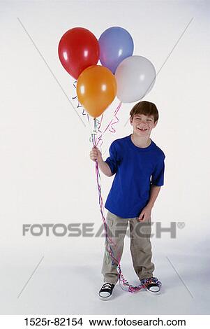 Portrait of a boy holding a bunch of balloons View Large Photo Image Picture - Portrait of a boy holding a bunch of balloons. Fotosearch