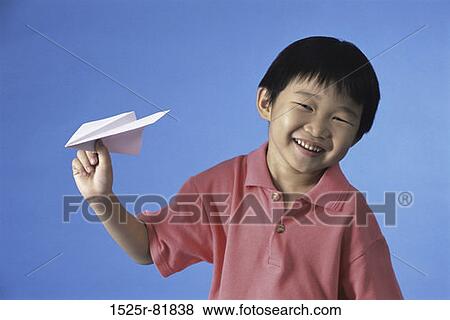 Portrait of a boy holding a paper plane smiling View Large Photo Image Stock Photo - Portrait of a boy holding a paper plane smiling. Fotosearch