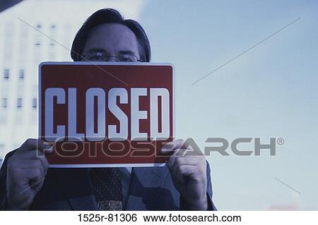 Portrait of a businessman holding a closed sign View Large Photo Image Stock Photograph - Portrait of a businessman holding a closed sign. Fotosearch