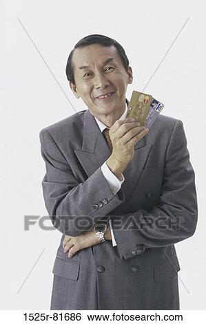 Portrait of a businessman holding credit cards View Large Photo Image Stock Photograph - Portrait of a businessman holding credit cards. Fotosearch