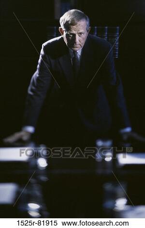 Portrait of a businessman leaning against a desk View Large Photo Image Stock Photography - Portrait of a businessman leaning against a desk. Fotosearch