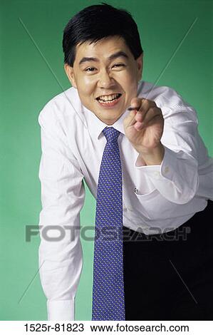 Stock Image - Portrait of a businessman pointing. Fotosearch