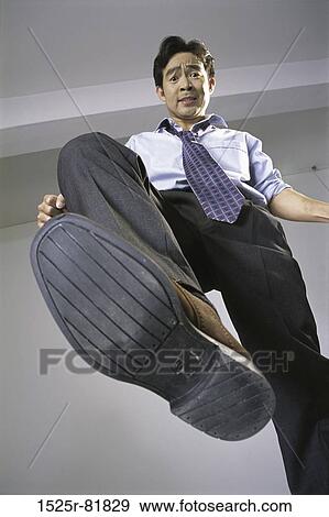 Portrait of a businessman showing his foot View Large Photo Image Stock Photo - Portrait of a businessman showing his foot. Fotosearch