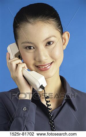 Stock Image - Portrait of a businesswoman talking on a telephone. Fotosearch